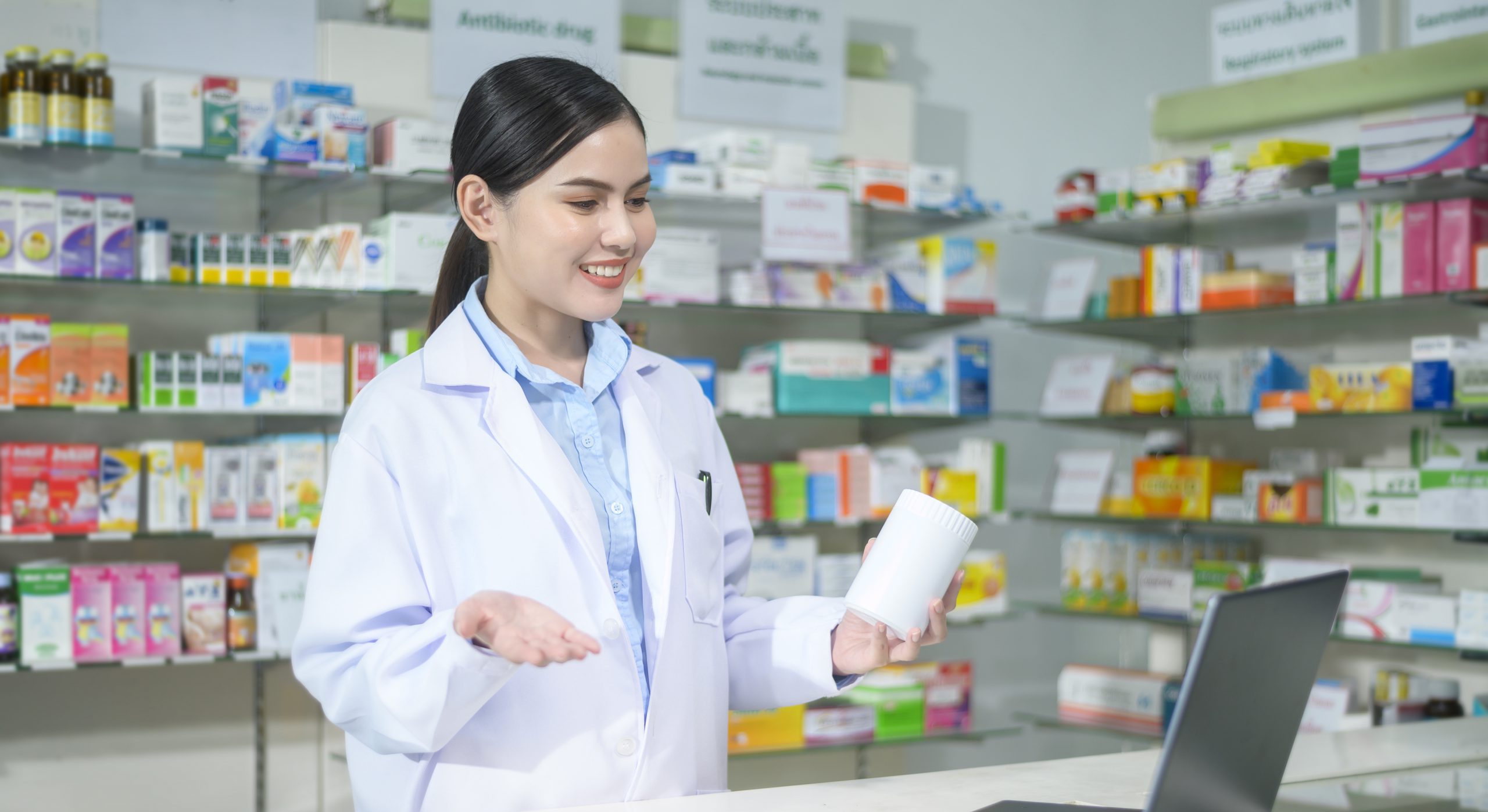 Female pharmacist counseling customer via video call in a modern pharmacy drugstore